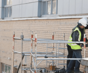 men on scaffold repairing a wall